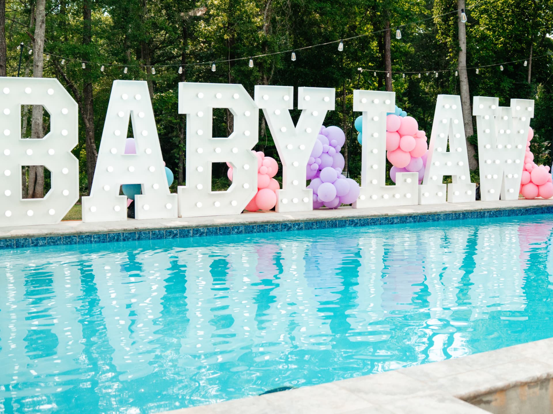 Marquee letters spelling Baby Law beside a pool