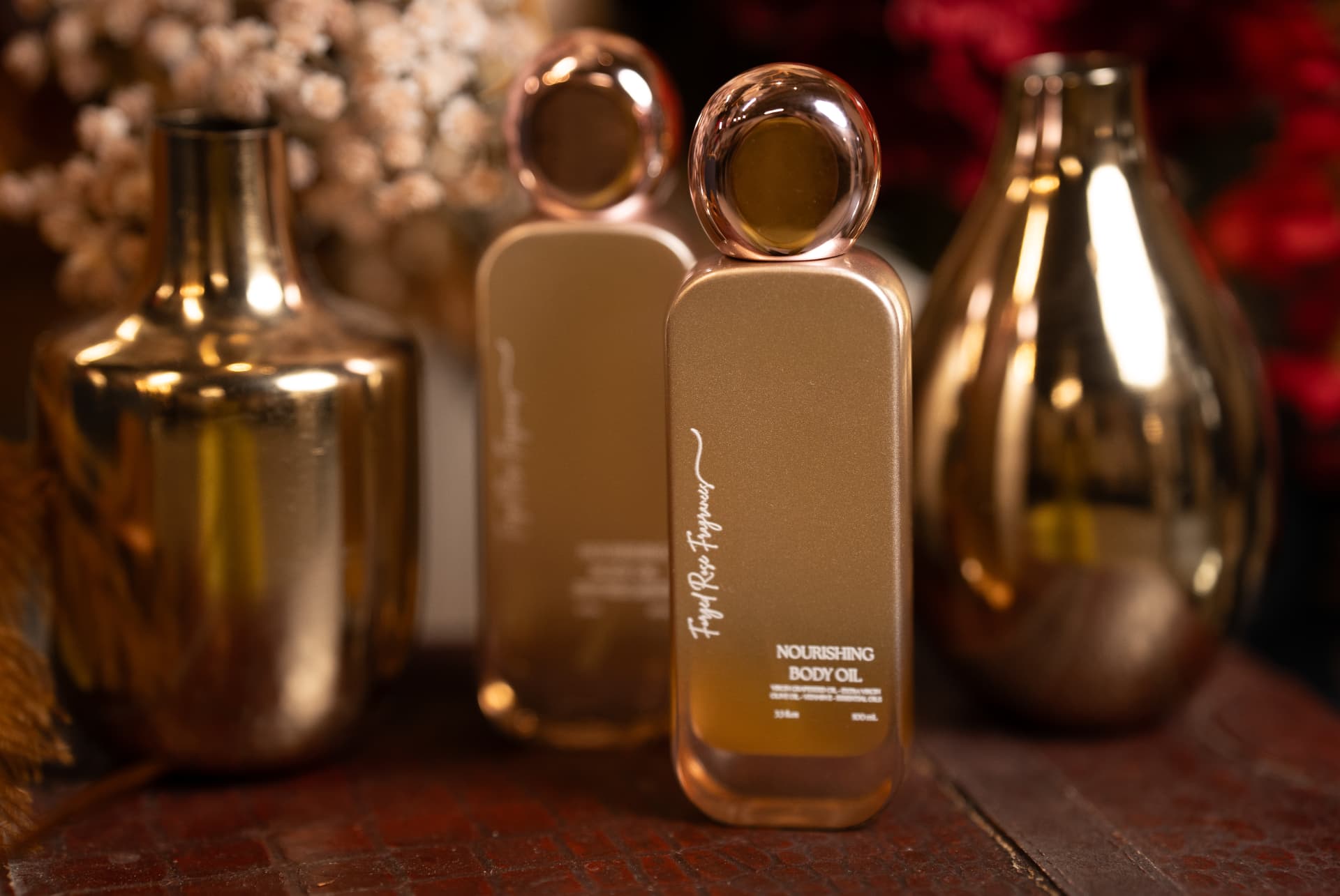 Gold nourishing body oil bottles styled with brass vases