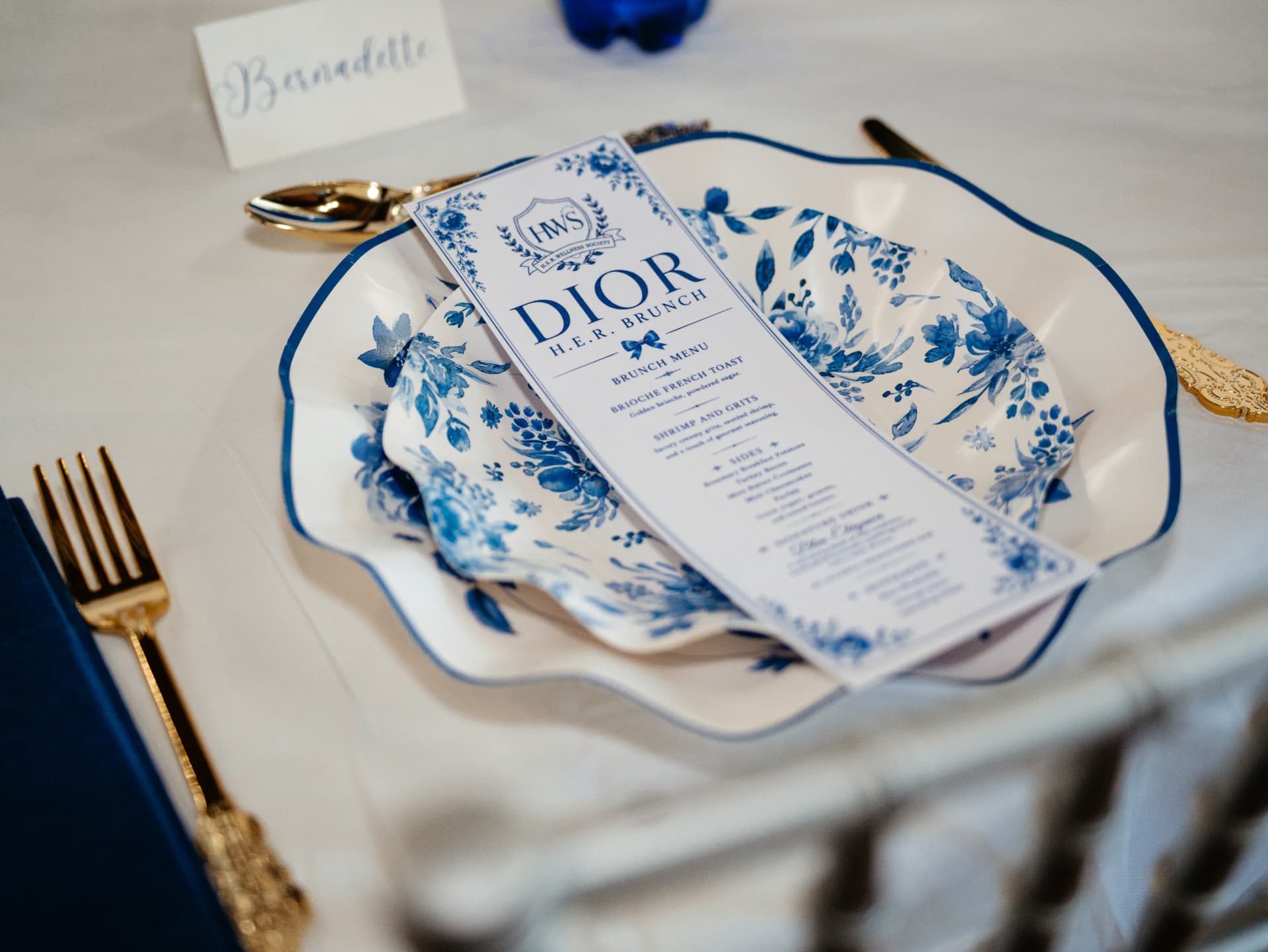 Dior H.E.R. Brunch menu on blue and white floral china
